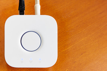 Smart Home Hub for home automation on wooden desktop with copyspace.