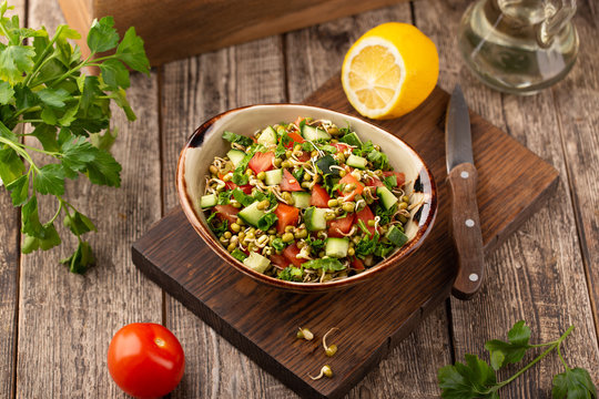 Healthy salad with mung beans, tomatoes, cucumber, lettuce and greens