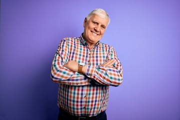 Senior handsome hoary man wearing casual colorful shirt over isolated purple background happy face...