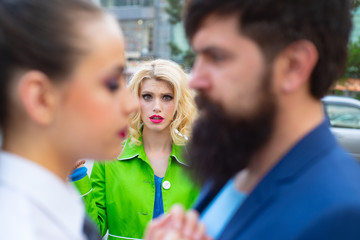 Cheating in marriage. Man looking other woman. Terribly jealous of them. Jealous woman look at couple in love on street. Unhappy girl feeling jealous.