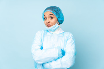 Young surgeon Indian woman in blue uniform making doubts gesture while lifting the shoulders