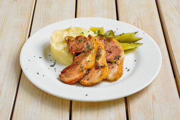 Baked bacon with mashed potato and pickle cucumber
