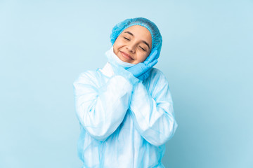 Young surgeon Indian woman in blue uniform making sleep gesture in dorable expression