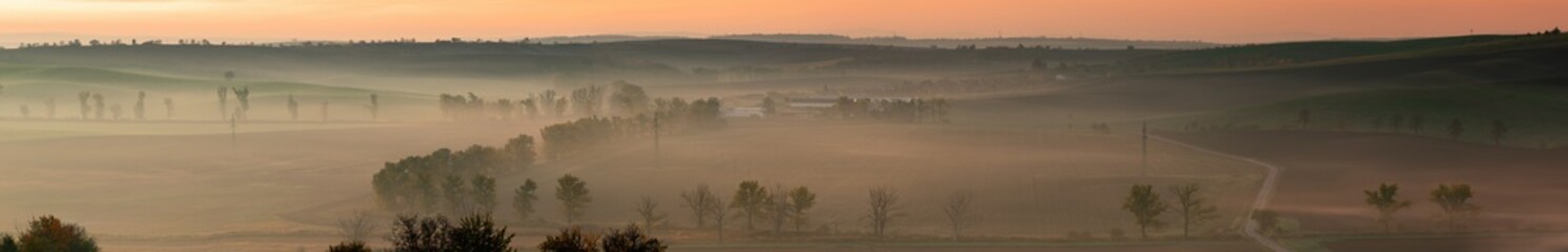 A wonderful large panorama of green Moravian fields shrouded in morning fog