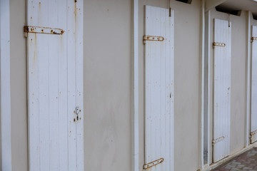 Winter sea mood in the Riviera Romagnola region of Italy. Closed beach cabins waiting for the summer season to start. Rusty hinges.