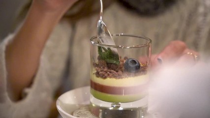lady eating sweet dessert in glass with silver spoon in slow motion