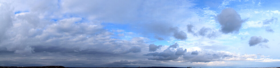 Naklejka na ściany i meble Spring. Daytime Panoramic photo of the cloudy sky, March, fresh air.