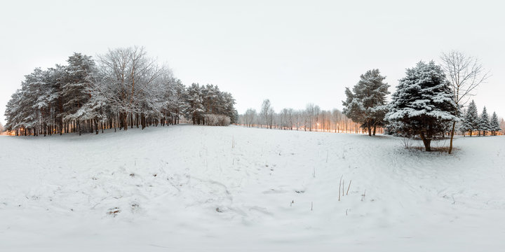 Image with 3D spherical panorama with 360 degree viewing angle. Snowy winter in park with trees at the evening. Burning lanterns. Ready for virtual reality in vr. Full equirectangular projection.