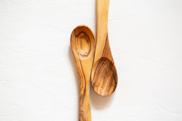Wooden spoons made of olive wood on a white background. Eco-friendly dishes.