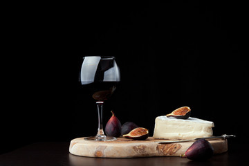 Fototapeta na wymiar Brie Cheese and Red Wine On Black