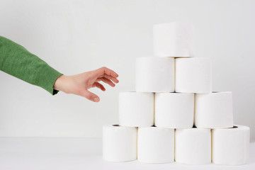 Woman holds a roll of tissue in hands on a white background. Concept of Covid-19 quarantine.Doomsday panic people panic.