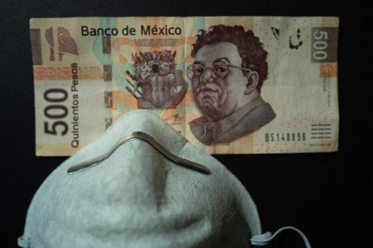 El billete de 500 pesos mexicanos est&aacute; a un lado del cubreboca.