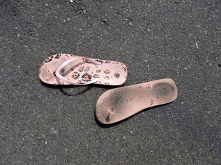 Flip flops on sunlit pavement