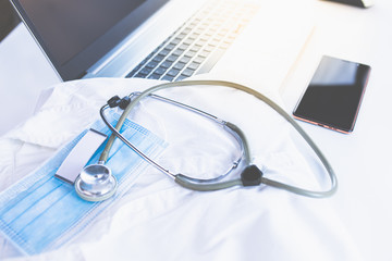 Home Office Medizin - Laptop mit Mundschutz, Stethoskop, Schutz gegen Virus, Infektion, Handy und...
