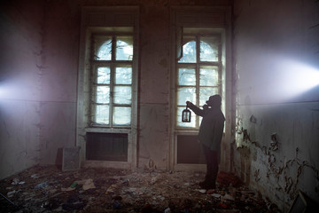 Dramatic portrait of a woman wearing a gas mask in a ruined building.