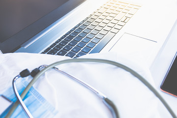 Home Office Medizin - Laptop mit Mundschutz, Stethoskop, Schutz gegen Virus, Infektion, Handy und...