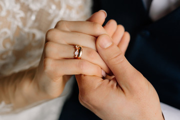 The groom holds the bride by the hand with ring. Beautiful elegant couple of newlyweds in love. Wedding concept. Close-up.