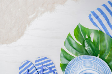 Flat lay composition with a summer hat and flip flops on a light background