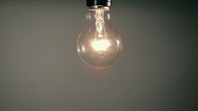 hand screwing vintage Edison Light bulb on light socket