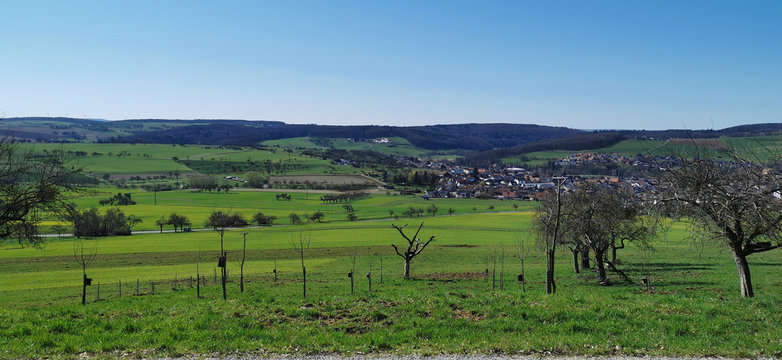 Blauer Himmel über grünem Tal mit Dorf im Spessart