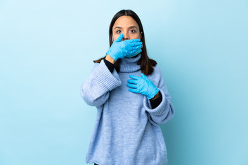 Young brunette mixed race woman protecting from the coronavirus with a mask and gloves over...