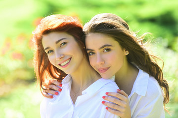 Fototapeta premium Beautiful woman in park. Two Beautiful redhead girl. Cheerful sister friend, embrace concept.