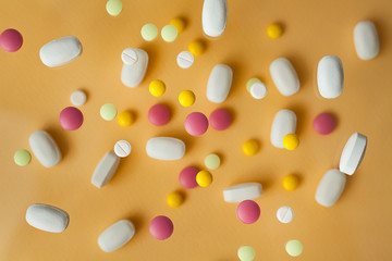 Pills for levitation. Pills on a yellow background that fall down, tablets. Medicine and health. Different types of pills