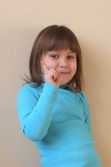 The little girl wags her finger. The child is Caucasian. Selective focus.