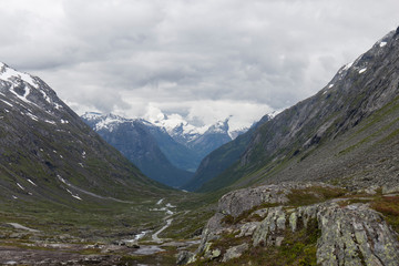 Fototapeta na wymiar Nordic mountainous landscape, high mountains with snowy peaks, cloudy, alpine landscape