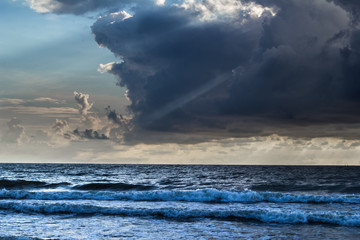 Stormy cloud above the Baltic sea with rays of sun shining throughout
