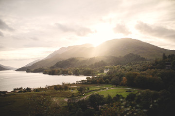 Highland in Scotland, view from the mountain to the valley with the village, the last rays of the...