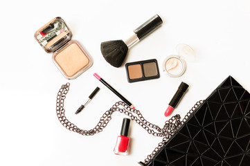 Make up cosmetic bag with professional accessories. Lipsticks and brushes in a black cosmetic bag in white background
