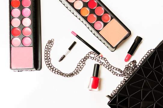 Make up cosmetic bag with professional accessories. Lipsticks and brushes in a black cosmetic bag in white background