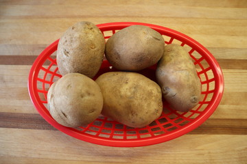 Cinq patates dans un panier rouge