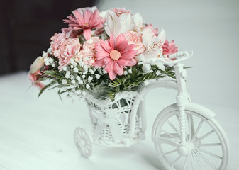 wedding bouquet in white basket on toy bicycle
