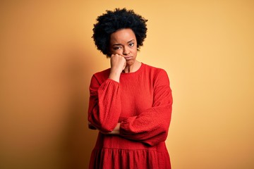Fototapeta na wymiar Young beautiful African American afro woman with curly hair wearing casual sweater thinking looking tired and bored with depression problems with crossed arms.