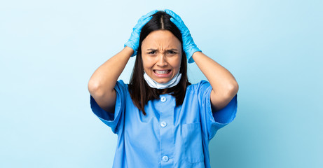 Surgeon woman over isolated blue background doing nervous gesture