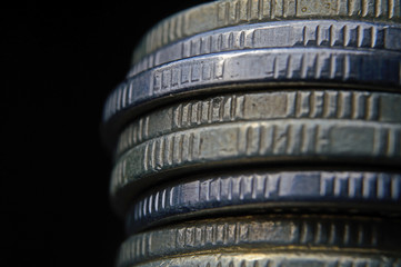 Closeup of coins stack isolated on black background