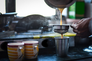 boy pouring a tea, in a yellow cup, Indian Tea (Chai) 