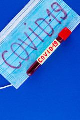 COVID-19. Test tube with blood identified by the COVID-19 coronavirus on classic blue background....