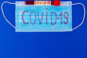 COVID-19. Test tube with blood identified by the COVID-19 coronavirus on classic blue background....