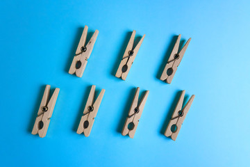 Wooden clothespins arranged in a chaotic order on a blue background.