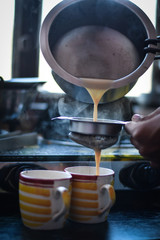 boy pouring a tea, in a yellow cup, Indian Tea (Chai) 