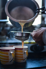 boy pouring a tea, in a yellow cup, Indian Tea (Chai) 