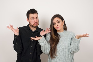 Puzzled and clueless young woman with arms out, shrugging her shoulders, saying: who cares, so what, I don't know. Negative human emotions, facial expressions, life perception and attitude.