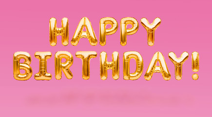Words HAPPY BIRTHDAY made of golden inflatable balloons floating on pink background. Gold foil...