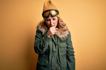 Middle age beautiful blonde skier woman wearing snow sportwear and ski goggles feeling unwell and coughing as symptom for cold or bronchitis. Health care concept.