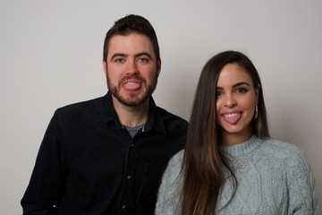 Beautiful Young  caucasian couple with happy and funny face smiling and showing tongue. Wearing casual clothes and standing against gray studio background.