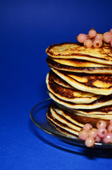 stack of pancakes with berries on a blue background