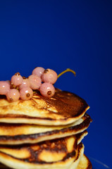 sprig of red currants on a stack of blue background snouts